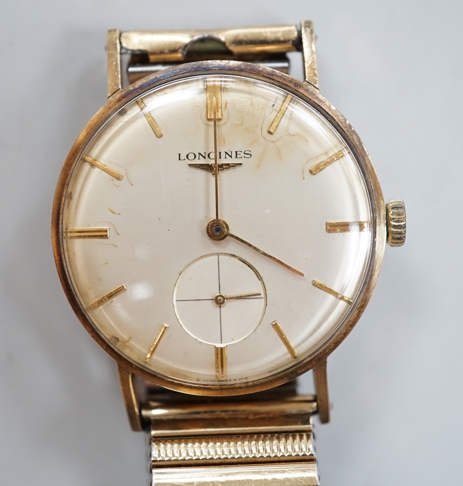 A gentleman's 9ct. gold Longines manual wind wrist watch, with engraved inscription, on an associated strap, boxed.